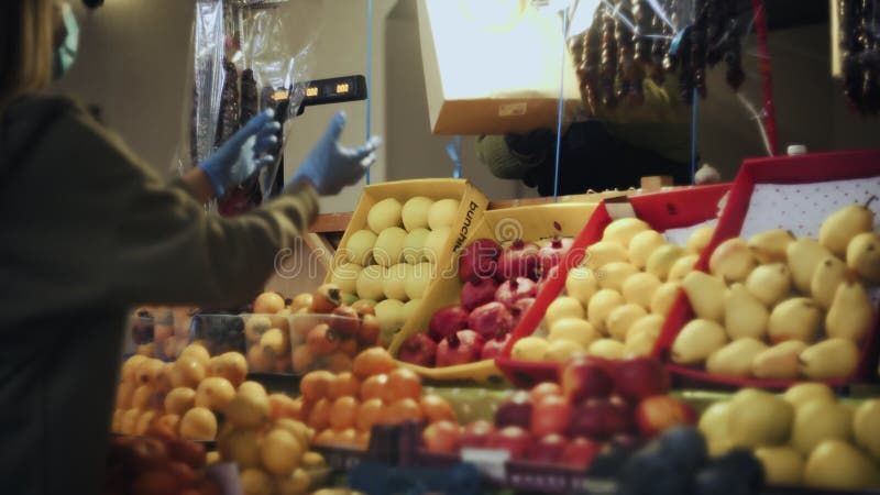 Vrouwelijke verkoper geeft een papieren zak met fruit aan klantenvrouw