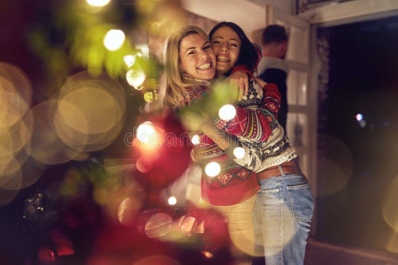 Vrouwelijke vrienden die en Kerstmis koesteren vieren royalty-vrije stock foto's Vrouwelijke vrienden die en Kerstmis koesteren vieren royalty-vrije stock foto's