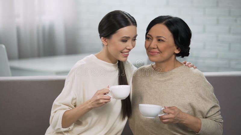 Vrouwelijke vrienden die thee, privé gesprek tussen moeder en dochter hebben