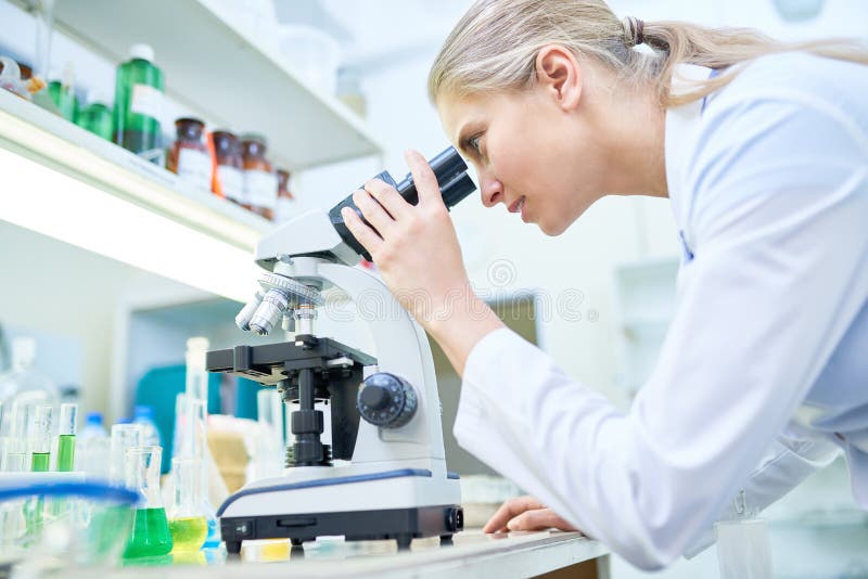 Vrouwelijke Wetenschapper die microscoop gebruikt