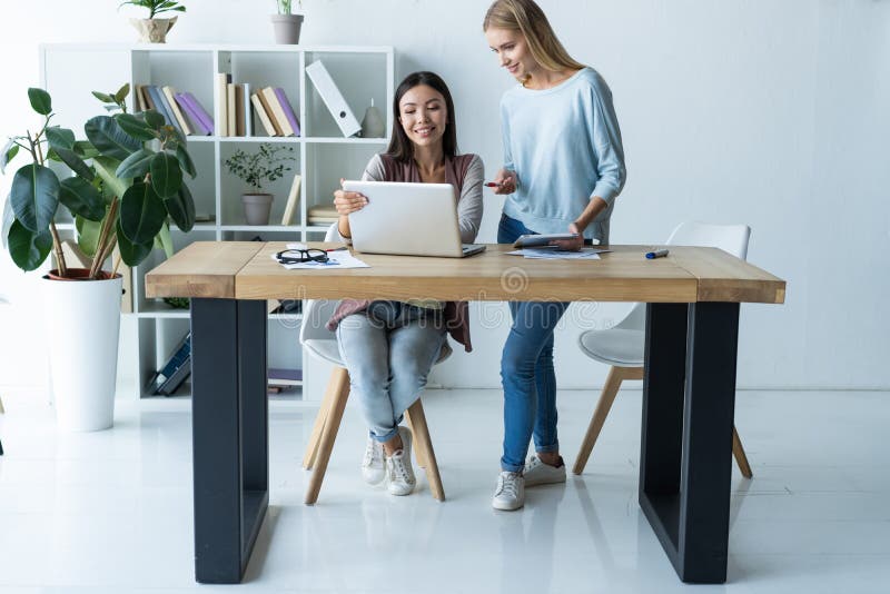 Vrouwen die, bureaubinnenland samenwerken Twee vrouwelijke collega's in bureau stock afbeeldingen Vrouwen die, bureaubinnenland samenwerken Twee vrouwelijke collega's in bureau stock afbeeldingen