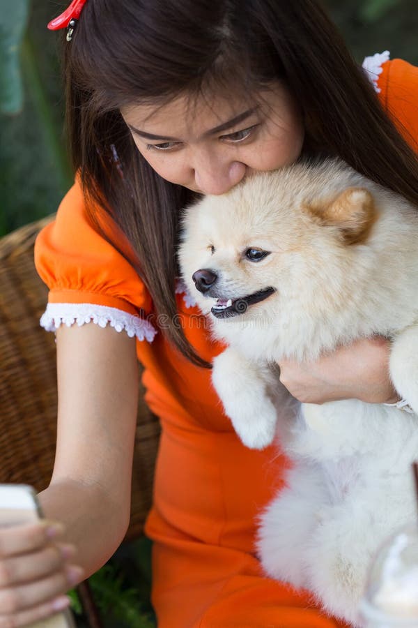 Vrouwen die mobiele telefoon selfie met pomeranian hond met behulp van royalty-vrije stock afbeeldingen Vrouwen die mobiele telefoon selfie met pomeranian hond met behulp van royalty-vrije stock afbeeldingen