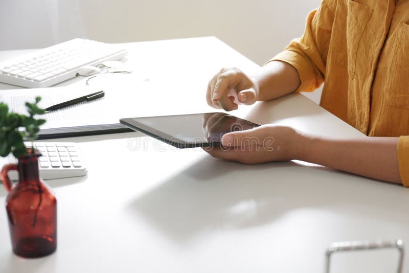 vrouwen die tablet gebruiken terwijl het werken in haar bureau stock afbeelding vrouwen die tablet gebruiken terwijl het werken in haar bureau stock afbeelding