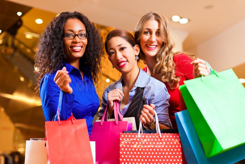 Vrouwen die in wandelgalerij met de decoratie van Kerstmis winkelen stock afbeelding Vrouwen die in wandelgalerij met de decoratie van Kerstmis winkelen stock afbeelding