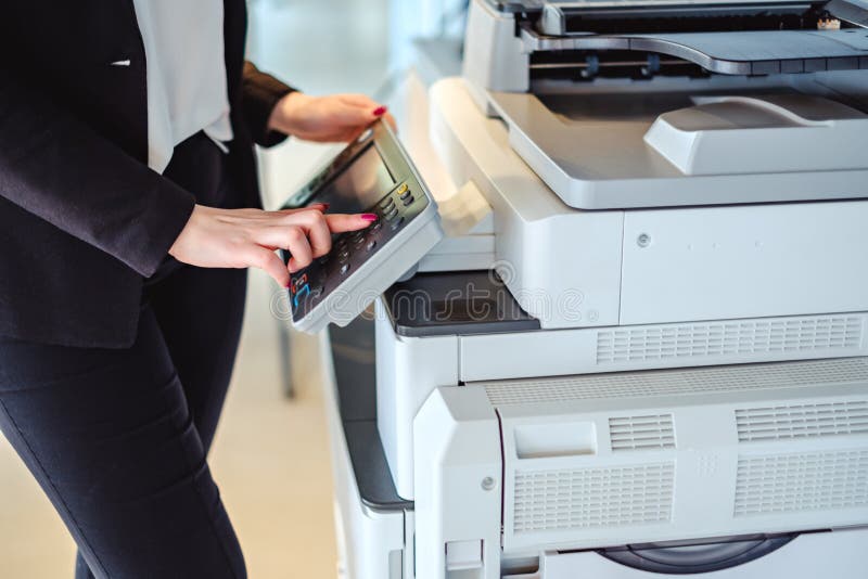 Vrouwen dringende knoop op een exemplaarmachine in het bureau