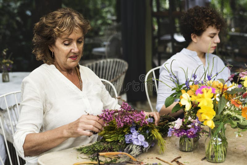 Vrouwen het schikken bloeit samen openlucht stock fotografie Vrouwen het schikken bloeit samen openlucht stock fotografie