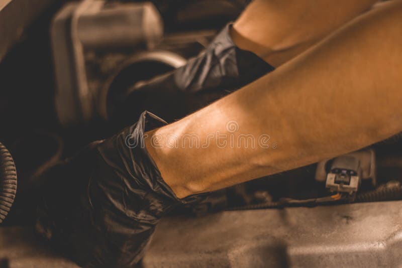 Vrouwen Mechanische veranderende bougies onder de kap van SUV in de winkel stock afbeeldingen Vrouwen Mechanische veranderende bougies onder de kap van SUV in de winkel stock afbeeldingen