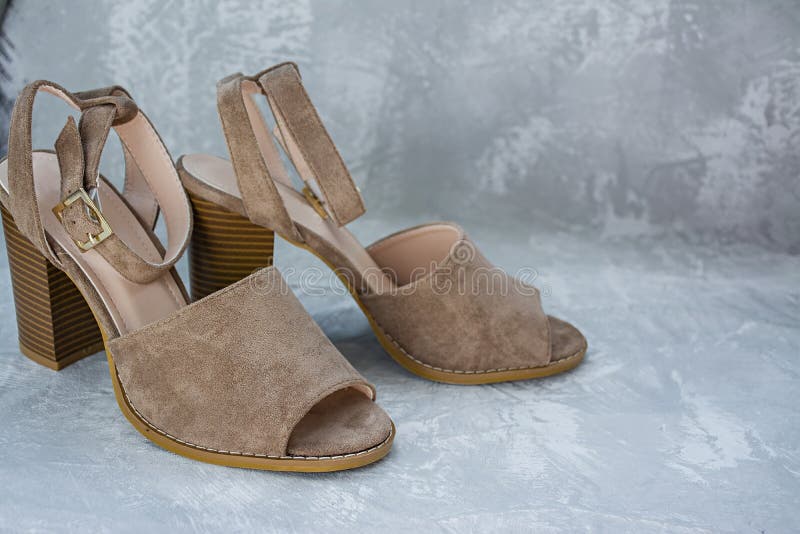 Vrouwen` s beige sandals De zomerschoeisel Lichte achtergrond Achtergrond onder het beton Ruimte voor tekst stock foto's Vrouwen` s beige sandals De zomerschoeisel Lichte achtergrond Achtergrond onder het beton Ruimte voor tekst stock foto's