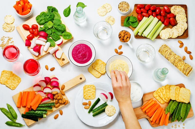 Vrouwen` s handen en variatie van gezonde veganistsnacks Groenten, crackers, onderdompeling en hummus royalty-vrije stock afbeelding Vrouwen` s handen en variatie van gezonde veganistsnacks Groenten, crackers, onderdompeling en hummus royalty-vrije stock afbeelding