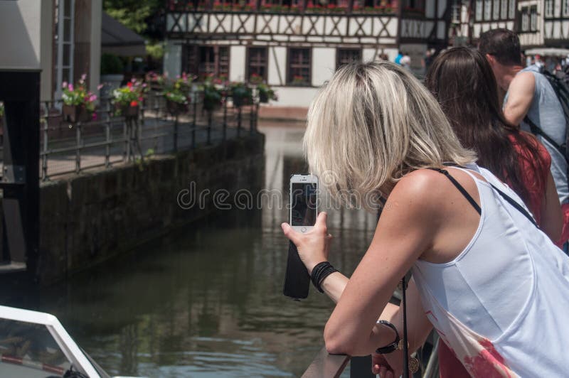 Vrouwending een beeld met telefoon bij weinig kwart van Frankrijk in Straatsburg royalty-vrije stock foto Vrouwending een beeld met telefoon bij weinig kwart van Frankrijk in Straatsburg royalty-vrije stock foto