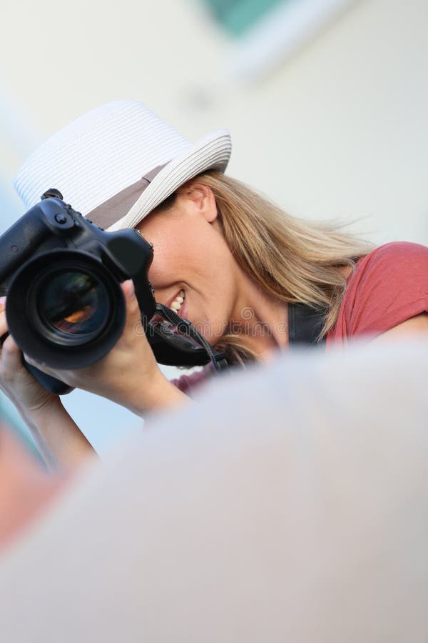 Vrouwenfotograaf die foto van een model nemen stock fotografie Vrouwenfotograaf die foto van een model nemen stock fotografie