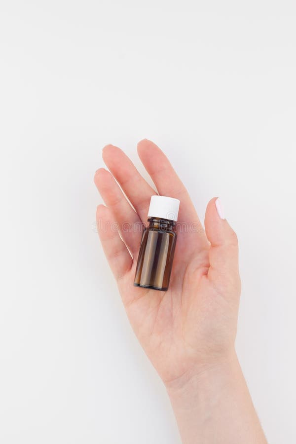 Vrouwenhand met kleine geïsoleerde glasfles royalty-vrije stock foto