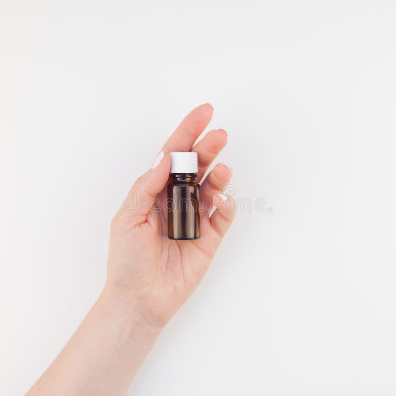 Vrouwenhand met kleine geïsoleerde glasfles stock afbeeldingen