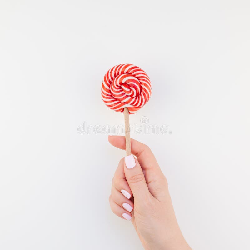 Vrouwenhand met rode lolly royalty-vrije stock afbeelding