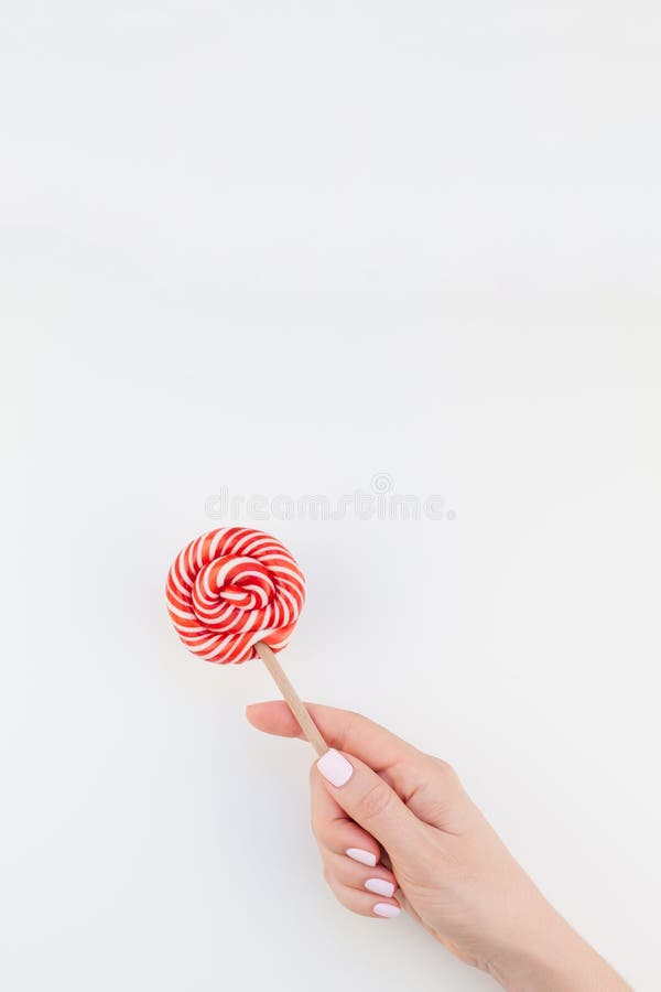 Vrouwenhand met rode lolly stock afbeelding