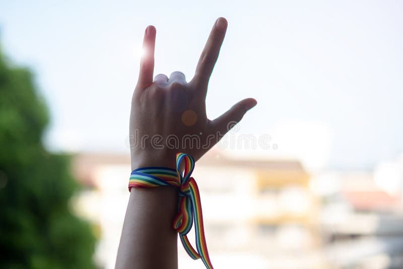 Vrouwenhanden die liefdeteken met LGBTQ-Regenbooglint tonen in de ochtend voor Lesbienne, Vrolijk, Biseksueel, Transsexueel en Zo royalty-vrije stock fotografie Vrouwenhanden die liefdeteken met LGBTQ-Regenbooglint tonen in de ochtend voor Lesbienne, Vrolijk, Biseksueel, Transsexueel en Zo royalty-vrije stock fotografie