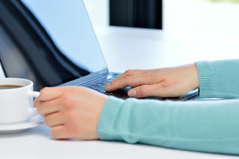 Vrouwenhanden die met laptop in een lijst van de koffiewinkel werken stock foto's Vrouwenhanden die met laptop in een lijst van de koffiewinkel werken stock foto's
