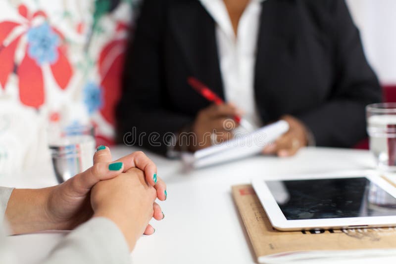 Woman in black suit interviewing another woman. Woman in black suit interviewing another woman.