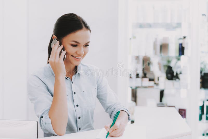 Vrouwenreceptionnist Speaks telefonisch in Schoonheidssalon stock afbeelding Vrouwenreceptionnist Speaks telefonisch in Schoonheidssalon stock afbeelding