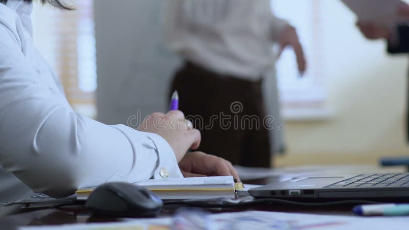 Vrouwensecretaresse klaar om in notitieboekje te schrijven, die op instructies van werkgever wachten