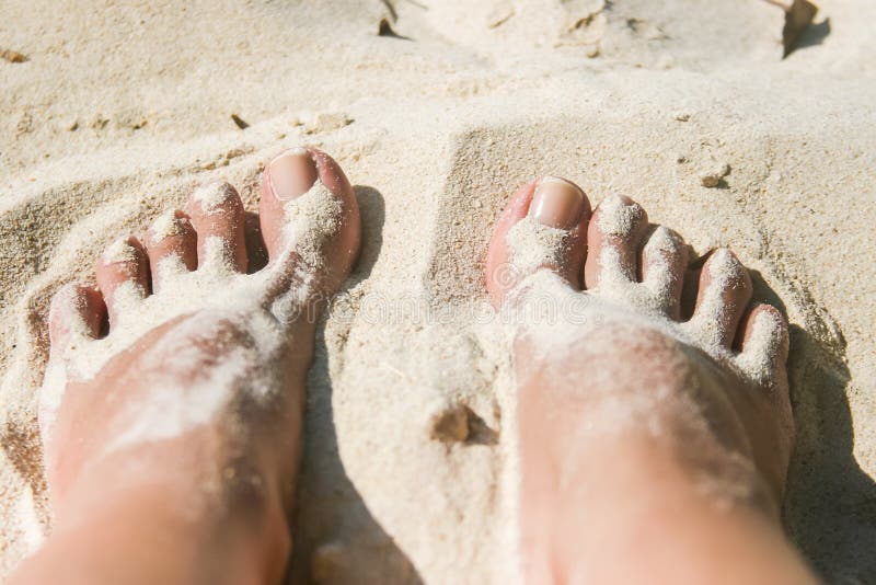 Vrouwenvoeten met wit zand bij het strand worden behandeld dat royalty-vrije stock foto Vrouwenvoeten met wit zand bij het strand worden behandeld dat royalty-vrije stock foto