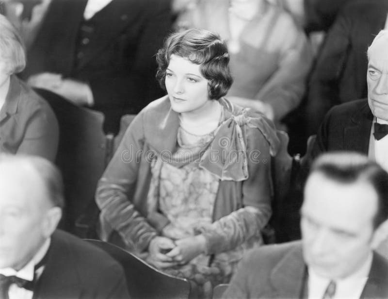 Vrouwenzitting in een auditorium die met gevouwen handen luisteren (Alle afgeschilderde personen leven niet langer en geen landgo stock foto's Vrouwenzitting in een auditorium die met gevouwen handen luisteren (Alle afgeschilderde personen leven niet langer en geen landgo stock foto's