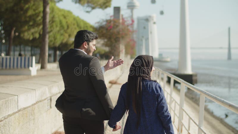 Vue arrière d'un couple arabe marchant le long du quai clips vidéos