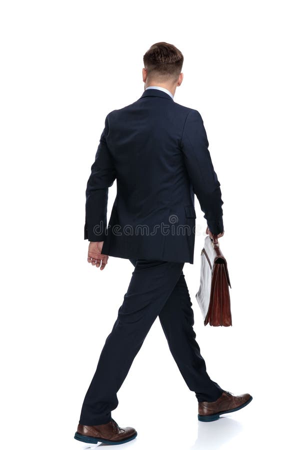 Vue arrière d'un homme d'affaires de marche tenant sa serviette images stock Vue arrière d'un homme d'affaires de marche tenant sa serviette images stock
