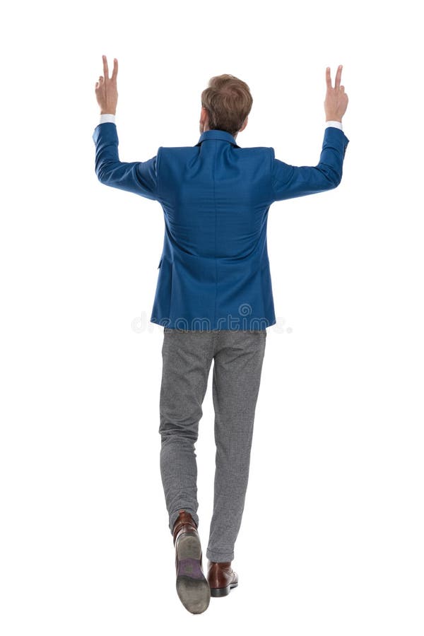Vue arrière d'un homme occasionnel marchant et faisant des gestes la paix photo libre de droits Vue arrière d'un homme occasionnel marchant et faisant des gestes la paix photo libre de droits