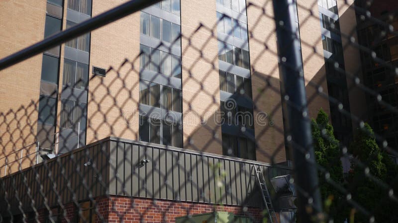 Vue arrière d'un immeuble d'hôtel ou de bureaux comme vu par derrière la barrière de maillon de chaîne