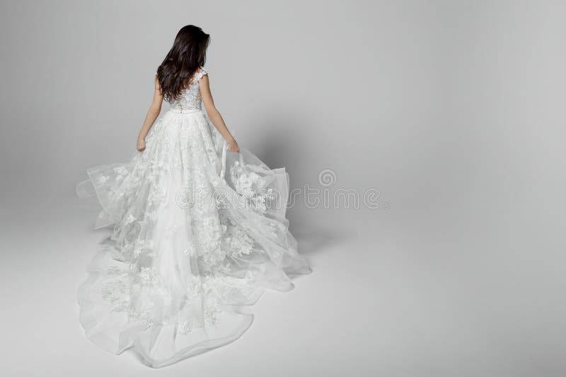 Vue arrière d'une belle jeune femme en épousant la robe blanche de princesse de vol, d'isolement sur un fond blanc Copiez l'espac image stock Vue arrière d'une belle jeune femme en épousant la robe blanche de princesse de vol, d'isolement sur un fond blanc Copiez l'espac image stock