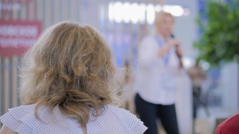 Vue arrière d'une femme écoutant une femme d'affaires méconnaissable parler sur scène clips vidéos