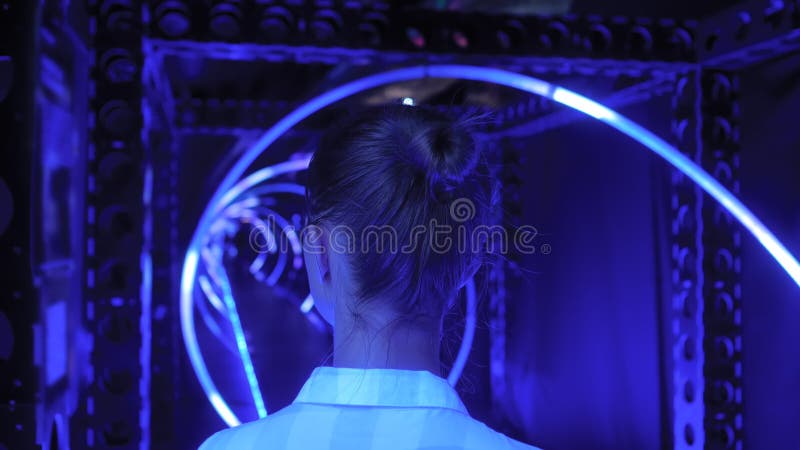 Vue arrière d'une jeune femme regardant autour de l'exposition futuriste interactive clips vidéos