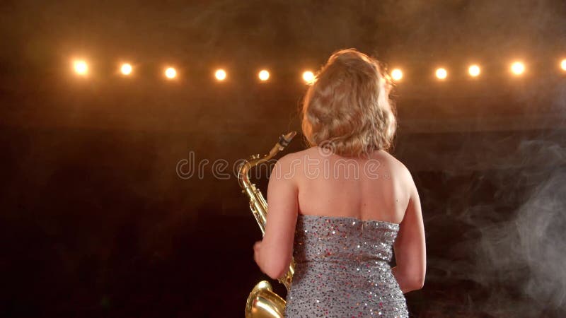 Vue arrière d'une saxophoniste féminine heureuse applaudissant à la foule excitée après le spectacle banque de vidéos