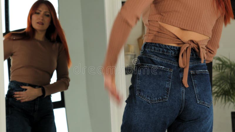 Vue arrière de la femme essayant de s'adapter dans un pantalon serré après avoir pris du poids banque de vidéos