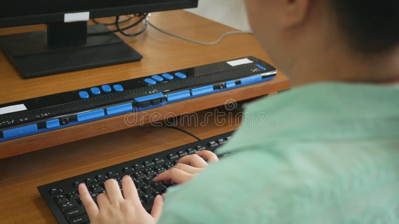 Vue arrière de la femme de personne aveugle utilisant l'affichage de clavier et en Braille d'ordinateur ou du terminal en Braille clips vidéos
