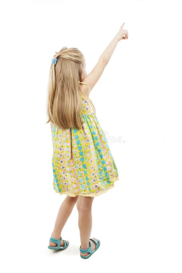 Vue arrière de la petite fille adorable se dirigeant au mur blanc d'isolement de vue arrière photo stock