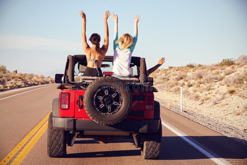Vue arrière des amis sur le voyage par la route conduisant dans la voiture convertible images libres de droits Vue arrière des amis sur le voyage par la route conduisant dans la voiture convertible images libres de droits