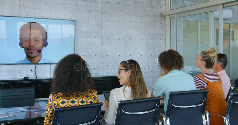 Vue arrière des cadres commerciaux de métis faisant la vidéoconférence dans le bureau moderne 4k banque de vidéos