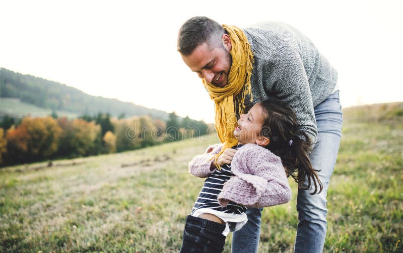 Vue arrière du jeune père s'amusant avec une petite fille dans la nature automnale photos libres de droits Vue arrière du jeune père s'amusant avec une petite fille dans la nature automnale photos libres de droits