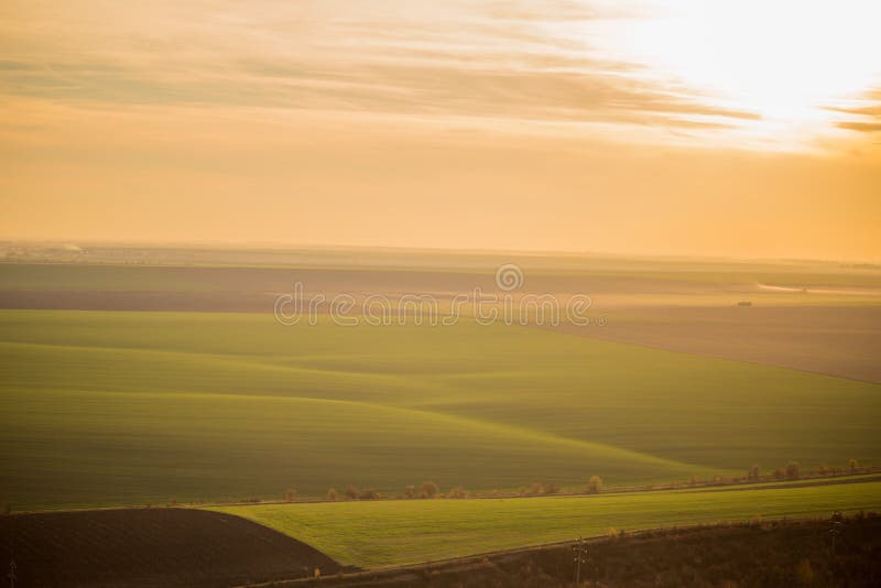 Vue aérienne d'un champ vert illimité au coucher du soleil image libre de droits Vue aérienne d'un champ vert illimité au coucher du soleil image libre de droits