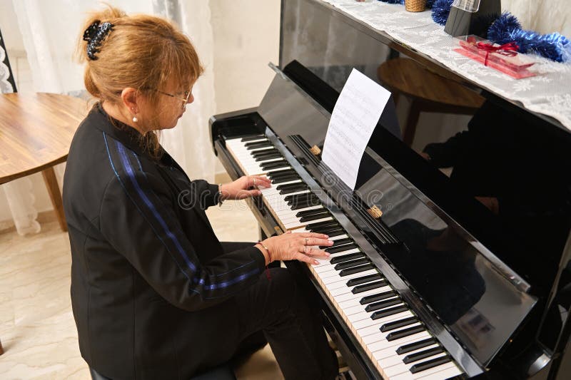 Vue aérienne d'une femme asiatique mature jouant du piano et chantant cours de piano à la maison photographie stock libre de droits