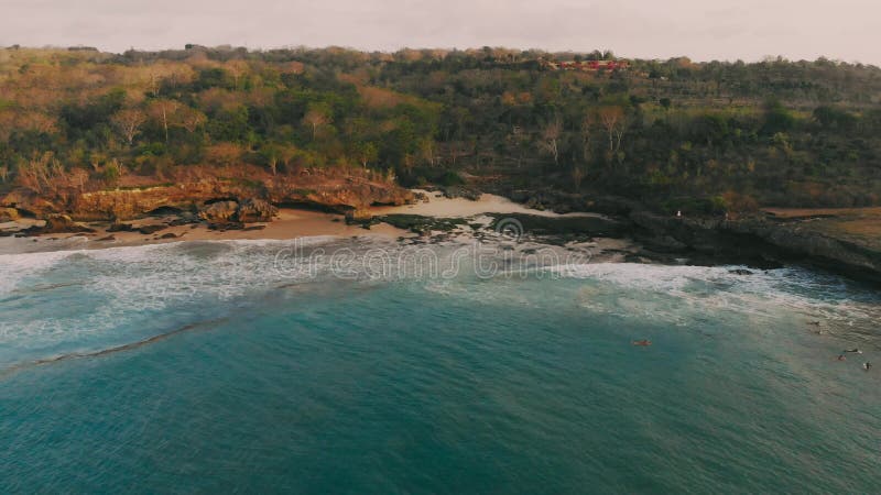 Vue aérienne de falaise, de plage et d'océan en île tropicale au coucher du soleil chaud clips vidéos