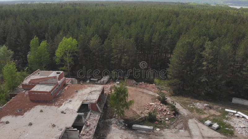 Vue aérienne de l'ancien bâtiment industriel démoli au milieu de la forêt Pile de béton et de briques, débris, décombres banque de vidéos