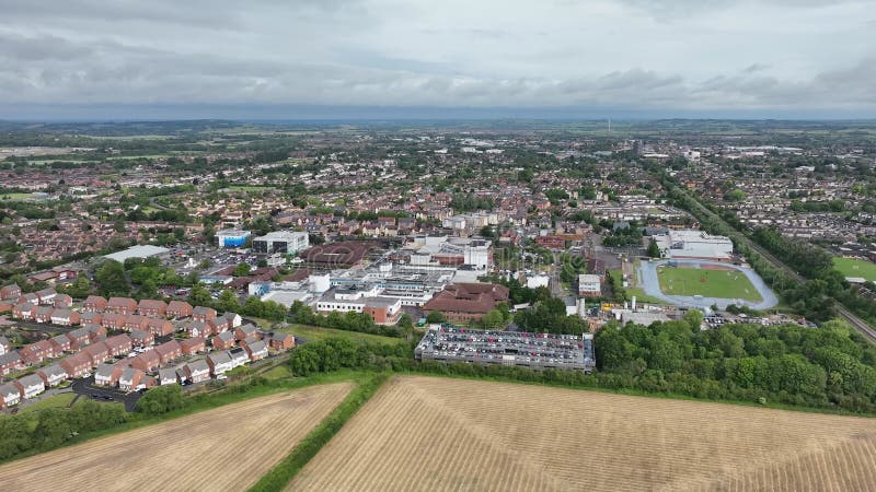 Vue aérienne de l'hôpital Stoke Mandeville entouré d'immeubles verdoyants et ciel nuageux clips vidéos