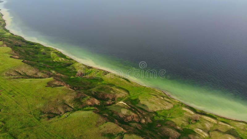 Vue aérienne de la côte avec terrain surréaliste avec des collines près calme eau verte estuaire de mer