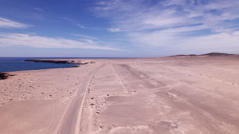 Vue aérienne de la piste d'atterrissage volcanique par les falaises et l'océan à Fuerteventura banque de vidéos