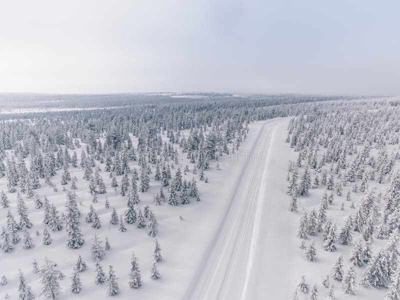 Vue aérienne de la route dans la forêt de neige d'hiver en Finlande image libre de droits Vue aérienne de la route dans la forêt de neige d'hiver en Finlande image libre de droits
