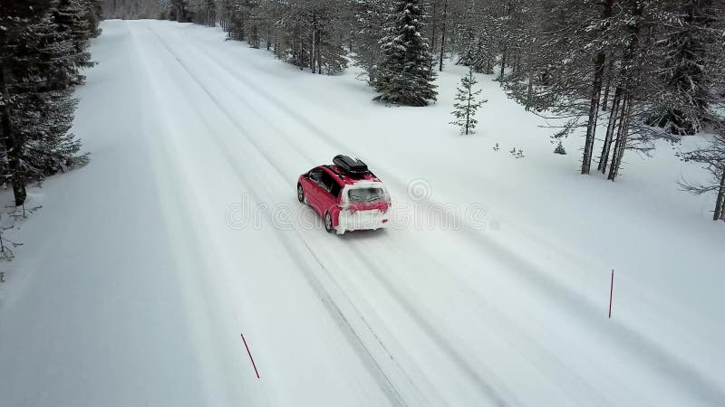 Vue aérienne de la seule voiture rouge sur la route dans le beau paysage d'hiver de la Laponie après chutes de neige banque de vidéos