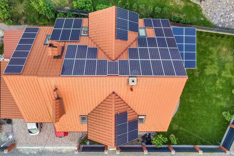 Aerial top view of new modern residential house cottage with blue shiny solar photo voltaic panels system on roof. Renewable ecological green energy production concept. Aerial top view of new modern residential house cottage with blue shiny solar photo voltaic panels system on roof. Renewable ecological green energy production concept.